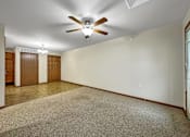 Thumbnail 7 of 22 - A room with a ceiling fan and carpeted floor.at Cornerstone Commons, Iowa, 50131