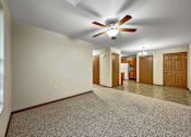 Thumbnail 6 of 22 - A room with a ceiling fan and carpeted floor.at Cornerstone Commons, Iowa  
