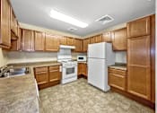 Thumbnail 9 of 22 - A kitchen with white appliances and wooden cabinets.at Cornerstone Commons, Johnston  