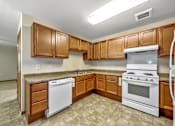 Thumbnail 10 of 22 - A kitchen with white appliances and wooden cabinets.at Cornerstone Commons, Iowa, 50131