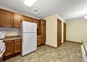 Thumbnail 8 of 22 - A kitchen with a white refrigerator and brown cabinets.at Cornerstone Commons, Johnston, 50131  
