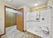 Thumbnail 13 of 22 - A bathroom with a walk-in shower and a wooden door.at Cornerstone Commons, Iowa  