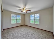 Thumbnail 3 of 22 - A room with a ceiling fan and two windows.at Cornerstone Commons, Johnston Iowa  