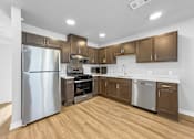 Thumbnail 6 of 26 - A kitchen with wooden floors and stainless steel appliances.at Hawthorne Pointe, Bondurant, IA 50035  