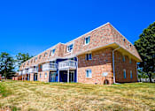 Thumbnail 17 of 19 - A red brick building with a balcony on the second floor at The Hampton Meadows Apartments, IA,50315