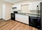Thumbnail 8 of 19 - A kitchen with black appliances and white cabinets at The Hampton Meadows Apartments, Des Moines, IA, 50315