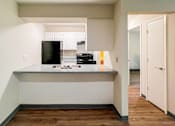 Thumbnail 10 of 19 - A kitchen with a black fridge and a black microwave at The Hampton Meadows Apartments, Des Moines, IA, 50315