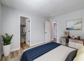 Thumbnail 6 of 19 - A bedroom with a bed, a cabinet, and a painting on the wall at The Hampton Meadows Apartments,Iowa, 50315