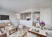 Thumbnail 3 of 19 - A modern living room with a white sofa, a coffee table, and a dining table set for two at The Hampton Meadows Apartments, Iowa, 50315
