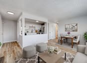 Thumbnail 2 of 19 - A modern living room with a kitchen in the background at The Hampton Meadows Apartments, IA,50315