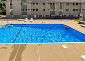 Thumbnail 7 of 21 - A large blue swimming pool in front of a building at The Ridges Apartments, IA, 50315