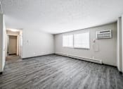 Thumbnail 11 of 21 - A room with a grey floor and a window with blinds at The Ridges Apartments, Iowa