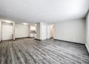 Thumbnail 13 of 21 - A spacious room with grey flooring and white walls at The Ridges Apartments, Des Moines