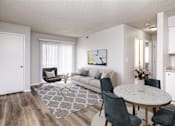 Thumbnail 1 of 18 - A living room with a white couch, a grey rug, and a round table with chairs.at Fish Creek, Norwalk, IA  