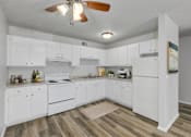Thumbnail 14 of 18 - A kitchen with white cabinets and a wood floor.at Fish Creek, Norwalk, 50211  