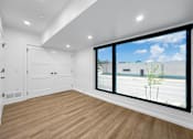 Thumbnail 15 of 30 - a living room with a large window and a door to the street at Matilda 235 Townhomes, Des Moines, 50309