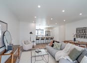 Thumbnail 6 of 30 - a living room with a couch and a kitchen with a table and chairs at Matilda 235 Townhomes, Des Moines