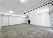 Thumbnail 22 of 30 - the interior of a garage with white walls and a concrete floor at Matilda 235 Townhomes, Des Moines