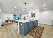 Thumbnail 9 of 30 - a kitchen with a blue island in the middle of it at Matilda 235 Townhomes, Iowa