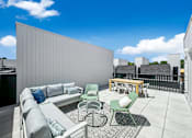 Thumbnail 25 of 30 - a rooftop patio with a couch and chairs and a table at Matilda 235 Townhomes, Des Moines, IA