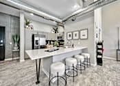 Thumbnail 2 of 53 - A kitchen with a white counter and bar stools.at Level, Des Moines Iowa   