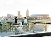 Thumbnail 6 of 53 - Two people sitting at a table on a balcony overlooking a city skyline.at Level, Des Moines, 50309  