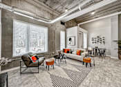 Thumbnail 11 of 53 - A living room with a grey couch, a black chair, and a black and white striped rug.at Level, Des Moines, IA 50309  