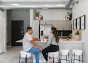 Thumbnail 15 of 53 - A man and a woman are sitting at a kitchen island.at Level, Des Moines, IA  