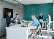 Thumbnail 16 of 53 - A group of people are gathered around a kitchen island.at Level, Des Moines, 50309  