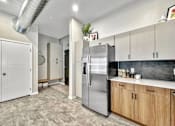 Thumbnail 20 of 53 - A kitchen with a stainless steel refrigerator and wooden cabinets.at Level, Des Moines Iowa   