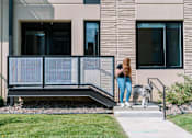 Thumbnail 21 of 53 - A woman and her dog are standing on a staircase outside a building.at Level, Des Moines, IA 50309  