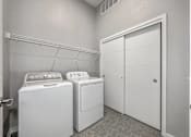 Thumbnail 32 of 53 - A laundry room with a washer and dryer and a white closet.at Level, Des Moines, IA  
