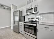 Thumbnail 35 of 53 - A modern kitchen with stainless steel appliances and white cabinets.at Level, Iowa   
