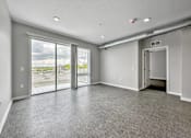 Thumbnail 36 of 53 - A spacious room with grey carpeting and a view of the outdoors through large windows.at Level, Des Moines Iowa   