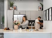 Thumbnail 45 of 53 - A woman is arranging flowers in a vase on a kitchen counter.at Level, Des Moines, IA 50309  