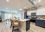 Thumbnail 12 of 34 - a kitchen and living room with an island and a sink at Linc, Des Moines Iowa   