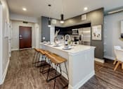 Thumbnail 16 of 34 - a kitchen with a large island with three stools at Linc, Iowa   