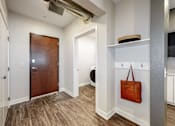 Thumbnail 18 of 34 - a hallway with a door to a bathroom and a bag on the wall at Linc, Iowa, 50309