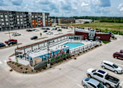 Thumbnail 30 of 34 - an aerial view of a parking lot with a pool and a building at Linc, Des Moines, IA  