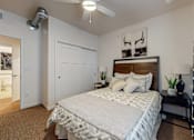 Thumbnail 11 of 35 - a bedroom with a bed and a ceiling fan at Melbourne Apartments, IA, 50320
