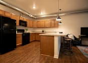 Thumbnail 3 of 35 - a kitchen with an island and a black refrigerator at Melbourne Apartments, Des Moines, IA,  50320