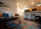 Thumbnail 5 of 35 - a living room and kitchen with a couch and a table at Melbourne Apartments, Des Moines