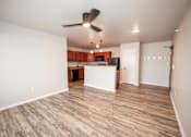 Thumbnail 6 of 56 - an empty living room with a kitchen and a ceiling fan at Meadowlark Place Apartments, Grimes