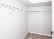 Thumbnail 27 of 56 - an empty closet with white walls and a white closet with a hanging rack at Meadowlark Place Apartments, Grimes, IA,  50111