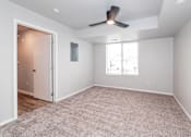 Thumbnail 11 of 56 - an empty living room with a ceiling fan and a window at Meadowlark Place Apartments, IA, 50111