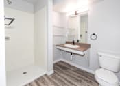 Thumbnail 28 of 56 - A white toilet sits next to a sink in a small bathroom at Meadowlark Place Apartments, Grimes, IA