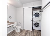 Thumbnail 29 of 56 - a bathroom with a toilet and a washing machine in it at Meadowlark Place Apartments, Grimes, Iowa