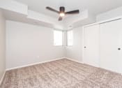 Thumbnail 26 of 56 - an empty room with a ceiling fan and a closet at Meadowlark Place Apartments, Grimes, IA