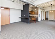 Thumbnail 9 of 42 - an empty room with a kitchen and a table in the middle at Eagle View Lofts, Des Moines, IA