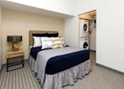 Thumbnail 17 of 42 - a bedroom with a bed and a washing machine at Eagle View Lofts, Iowa